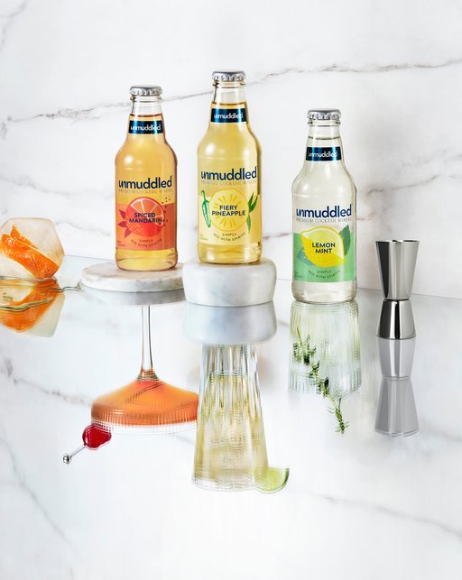 A stylized photo of the 3 Unmuddled flavors in 12 ounce glass bottles